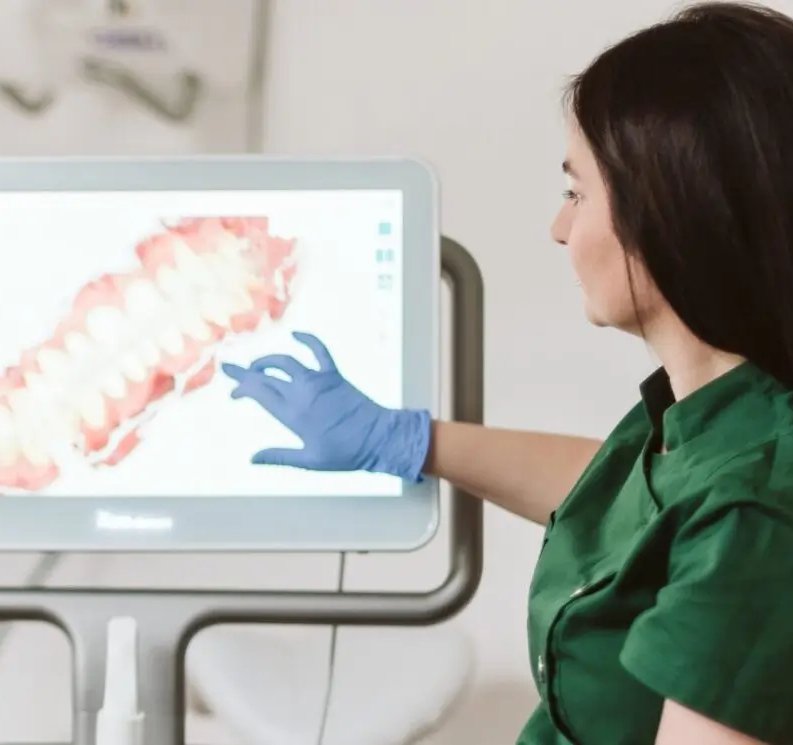 Lekarka pokazuje pacjentce skan 3D zębów na monitorze